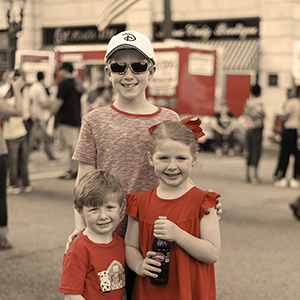 Kids posing at Cheerwine Festival 2018 with bottle of Cheerwine